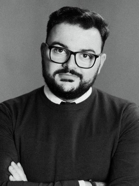 Mihai Damian in glasses and a dark sweater, black and white photo